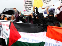 Muslim women are wearing hijabs, showing a slogan, and holding posters along with Palestine and Indian National Flags during a protest rally...