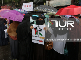 A Muslim woman is holding a poster during a protest rally, amid the ongoing conflict in Gaza between Israel and Hamas, in Kolkata, eastern I...