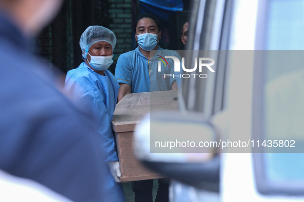 Dead body management staff at the morgue of Tribhuvan University Teaching Hospital are loading a body of the victim of the Saurya Airlines c...