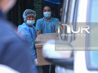 Dead body management staff at the morgue of Tribhuvan University Teaching Hospital are loading a body of the victim of the Saurya Airlines c...