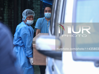 Dead body management staff at the morgue of Tribhuvan University Teaching Hospital are loading a body of the victim of the Saurya Airlines c...