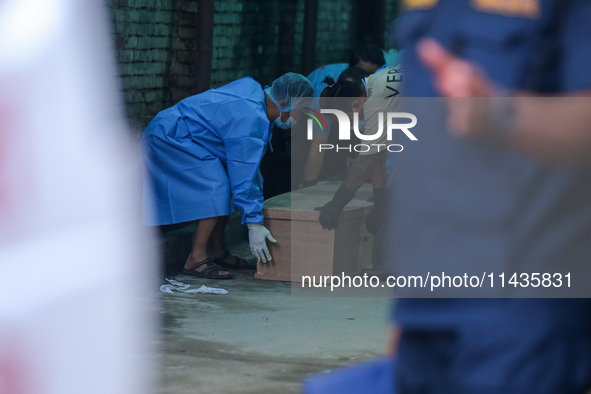 Dead body management officials are lifting a coffin containing the body of a deceased in the Saurya Airlines crash at a morgue in Kathmandu,...