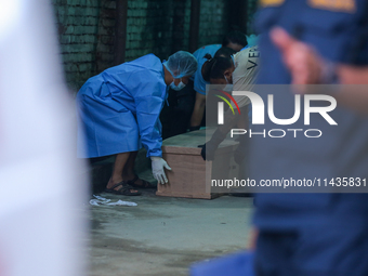 Dead body management officials are lifting a coffin containing the body of a deceased in the Saurya Airlines crash at a morgue in Kathmandu,...