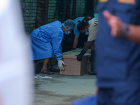 Dead body management officials are lifting a coffin containing the body of a deceased in the Saurya Airlines crash at a morgue in Kathmandu,...