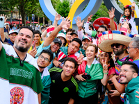 Mexican fans are taking pictures in front of the Olympic rings on the day of the opening ceremony of the Paris Olympics. (