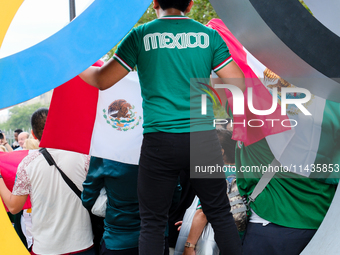 A Mexican supporter is standing in an Olympic ring on the Place de la Bastille in Paris. (