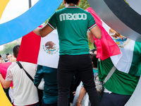 A Mexican supporter is standing in an Olympic ring on the Place de la Bastille in Paris. (