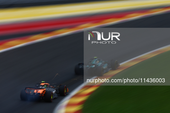 Fernando Alonso of Aston Martin Aramco and Lando Norris of McLaren during second practice ahead of the Formula 1 Belgian Grand Prix at Spa-F...