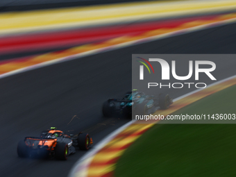 Fernando Alonso of Aston Martin Aramco and Lando Norris of McLaren during second practice ahead of the Formula 1 Belgian Grand Prix at Spa-F...