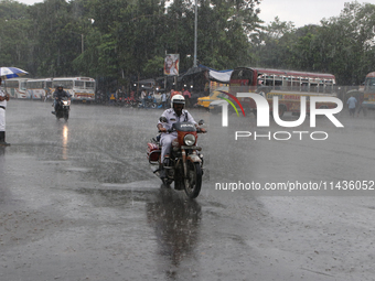 A traffic sergeant is riding an Enfield Bullet Bike in the monsoon rain in Kolkata, India, on July 26, 2024. (