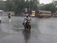 A traffic sergeant is riding an Enfield Bullet Bike in the monsoon rain in Kolkata, India, on July 26, 2024. (