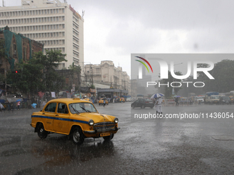 A Yellow Ambassador Taxi is riding in the heavy rainfall in Kolkata, India, on July 26, 2024. (