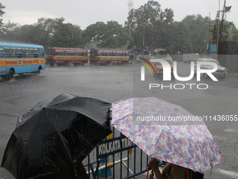 People are holding umbrellas as they are walking in the monsoon rain in Kolkata, India, on July 26, 2024. (