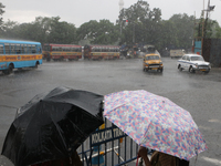 People are holding umbrellas as they are walking in the monsoon rain in Kolkata, India, on July 26, 2024. (