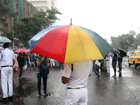 The police are holding umbrellas as they are walking in the monsoon rain in Kolkata, India, on July 26, 2024. (