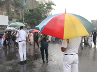 The police are holding umbrellas as they are walking in the monsoon rain in Kolkata, India, on July 26, 2024. (