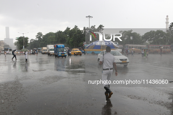 The police are holding umbrellas as they are walking in the monsoon rain in Kolkata, India, on July 26, 2024. 