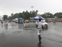 The police are holding umbrellas as they are walking in the monsoon rain in Kolkata, India, on July 26, 2024. (