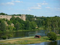 People are seen sunbathing on the banks of the Narva River in Narva, Estonia on 24 July, 2024. Estonian authorities have closed the bridge t...