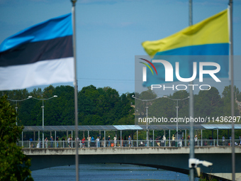 People are seen crossing the border with Russia with Estonia and Ukraine flags flying in Narva, Estonia on 24 July, 2024. Estonian authoriti...