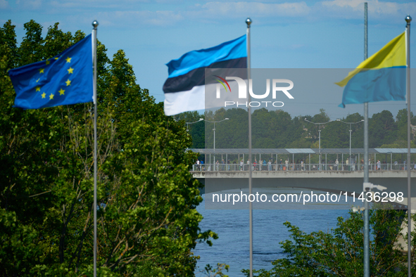 People are seen crossing the border with Russia with EU, Estonia and Ukraine flags flying in Narva, Estonia on 24 July, 2024. Estonian autho...