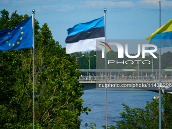 People are seen crossing the border with Russia with EU, Estonia and Ukraine flags flying in Narva, Estonia on 24 July, 2024. Estonian autho...