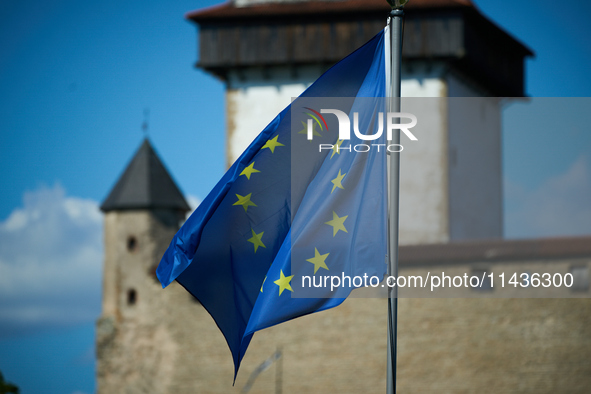 An EU flag is see flying with the Narva Castle in the background in Narva, Estonia on 24 July, 2024. Estonian authorities have closed the br...