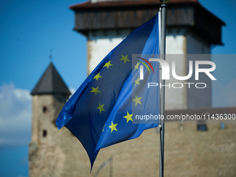 An EU flag is see flying with the Narva Castle in the background in Narva, Estonia on 24 July, 2024. Estonian authorities have closed the br...