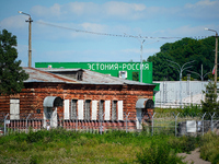 A building with the words ''Estonia-Russia'' is seen in Ivangorod, Russia with people looking on in the foreground in Narva, Estonia on 24 J...