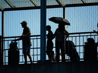 People waiting to cross the border to Russia are seen on the Frienship Bridge from the bank of the Narva River in Narva, Estonia on 24 July,...