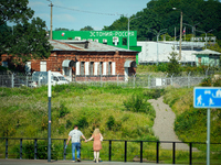 A building with the words ''Estonia-Russia'' is seen in Ivangorod, Russia with people looking on in the foreground in Narva, Estonia on 24 J...