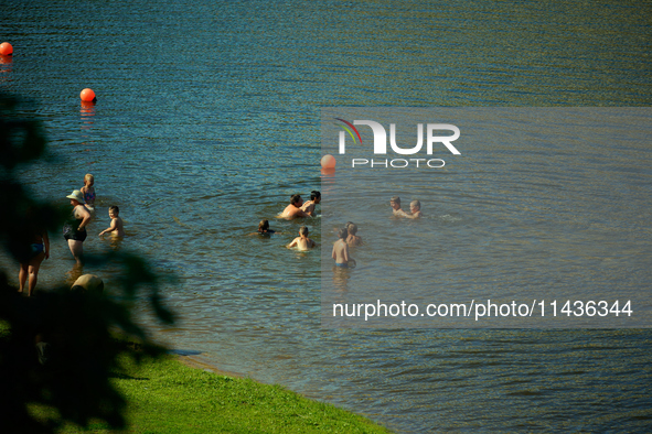 People are seen in the Narva River in Narva, Estonia on 24 July, 2024. Estonian authorities have closed the bridge that connects Russia and...