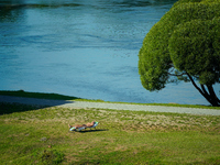 A man is seen sunbathing on the Narva River in Narva, Estonia on 24 July, 2024. Estonian authorities have closed the bridge that connects Ru...