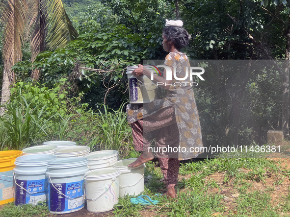 A woman is filling and carrying buckets of drinking water in Pathanamthitta, Kerala, India, on April 05, 2024. 