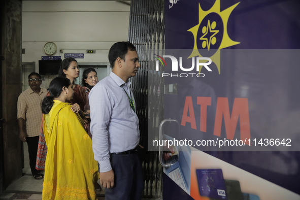 People are waiting in queue for cash withdrawal from a bank as broadband internet is being restored after five days of outage following a re...