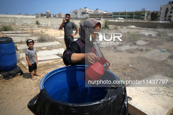 Displaced Palestinians from the eastern part of Khan Yunis are staying at a temporary camp set up in the grounds of a cemetery in the wester...