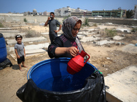 Displaced Palestinians from the eastern part of Khan Yunis are staying at a temporary camp set up in the grounds of a cemetery in the wester...