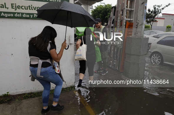 Several people are trying to cross the street after flooding in various areas of Mexico City 