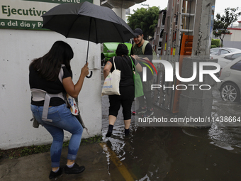 Several people are trying to cross the street after flooding in various areas of Mexico City (