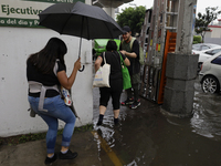 Several people are trying to cross the street after flooding in various areas of Mexico City (