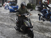 Motorcyclists are riding along Avenida Tlahuac in Mexico City after flooding is reported in various areas of the capital. (