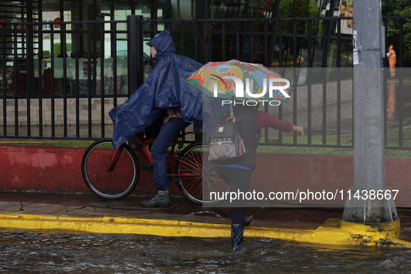 Several people are trying to cross the street after flooding in various areas of Mexico City 