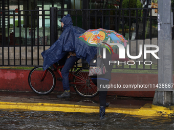 Several people are trying to cross the street after flooding in various areas of Mexico City (