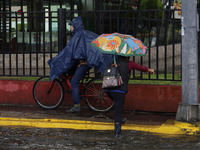 Several people are trying to cross the street after flooding in various areas of Mexico City (