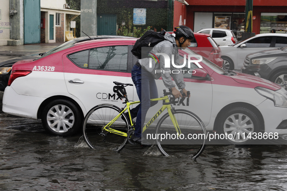 A cyclist is riding on Avenida Tlahuac in Mexico City after flooding is reported in various areas of the capital. 