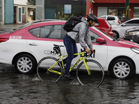 A cyclist is riding on Avenida Tlahuac in Mexico City after flooding is reported in various areas of the capital. (