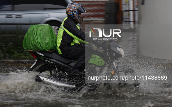 Motorcyclists are riding along Avenida Tlahuac in Mexico City after flooding is reported in various areas of the capital. 