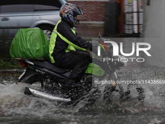 Motorcyclists are riding along Avenida Tlahuac in Mexico City after flooding is reported in various areas of the capital. (