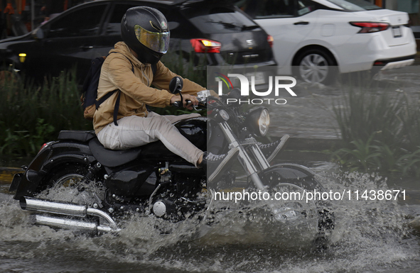 Motorcyclists are riding along Avenida Tlahuac in Mexico City after flooding is reported in various areas of the capital. 