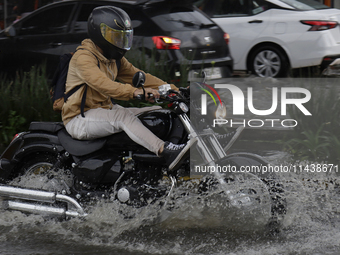 Motorcyclists are riding along Avenida Tlahuac in Mexico City after flooding is reported in various areas of the capital. (